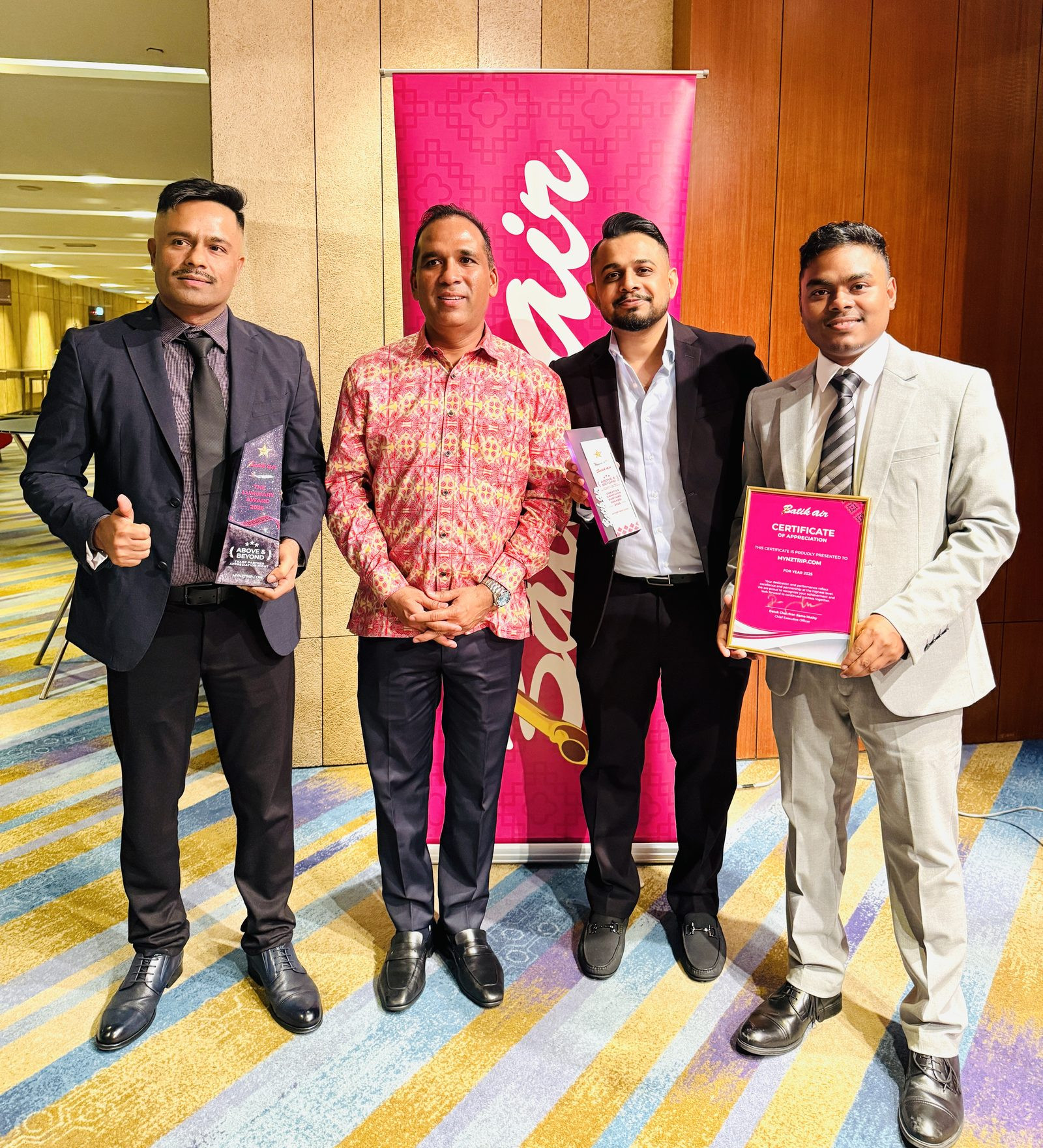 mynztrip team with Batik Air Malaysia CEO Datuk Chandran Rama Muthy, holding Batik Air awards and a certificate of appreciation